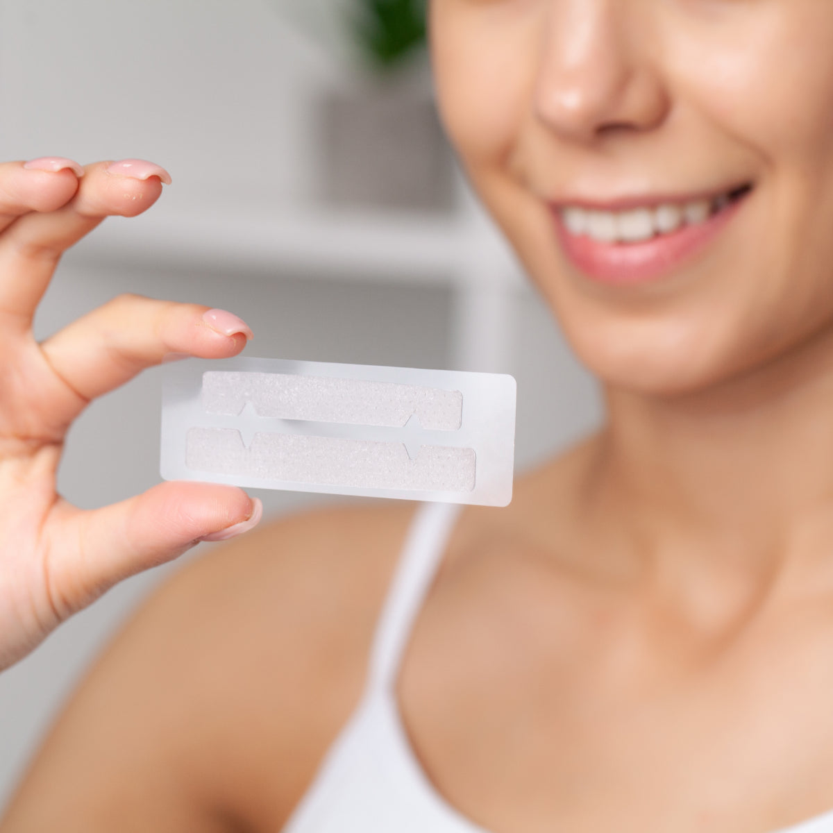 The lady holding the teeth whitening strips